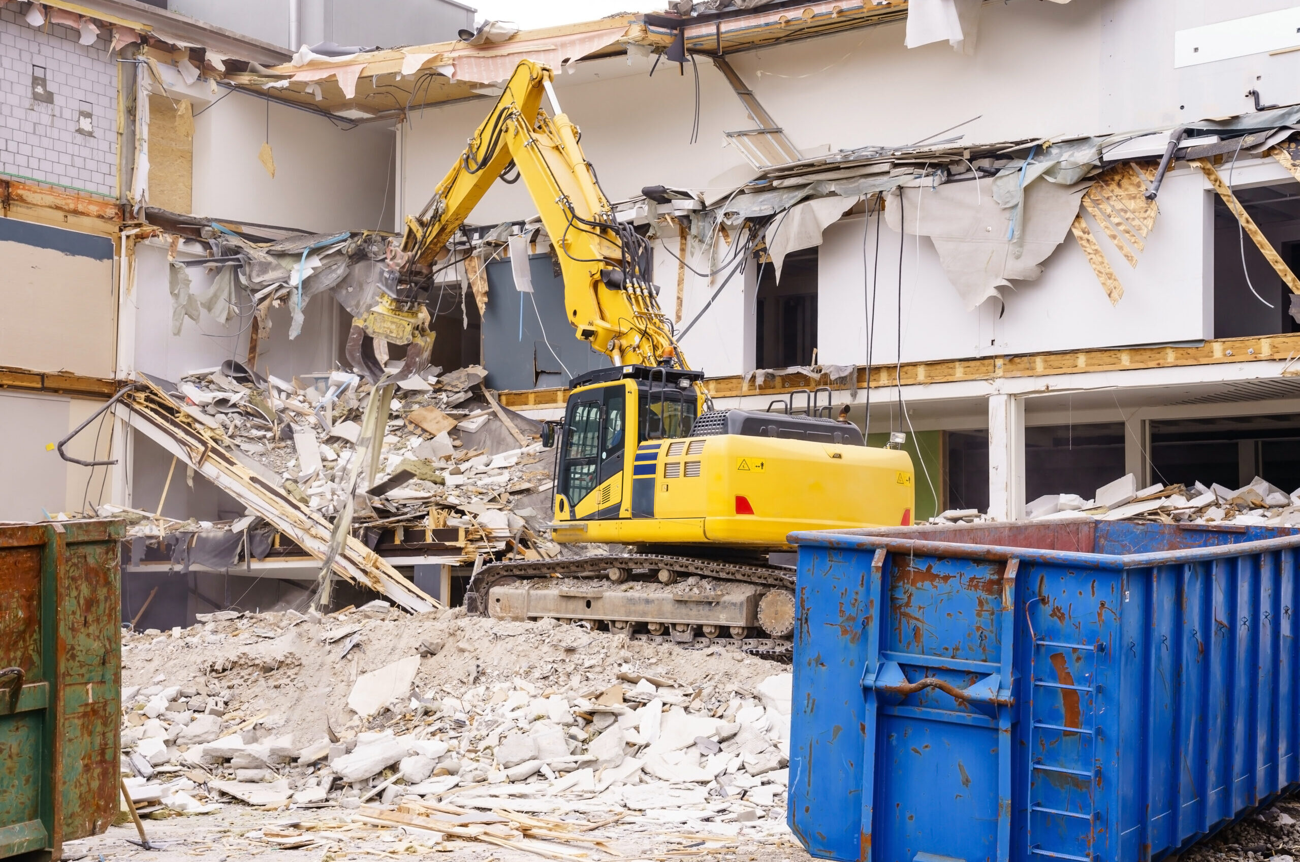 Hydraulic excavator working at the demolition of an old industrial building.